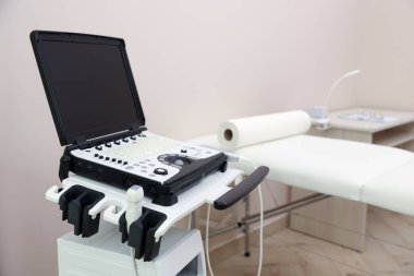 Modern ultrason makinesi ve klinikte muayene yatağı