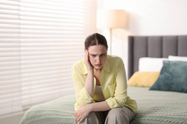 Evde baş ağrısı çeken genç bir kadın.