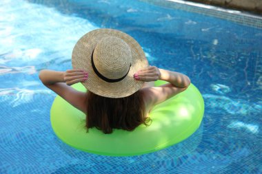 Yüzme havuzunda şişme yüzüklü kız, arka manzara