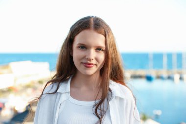 Deniz kıyısındaki güzel genç kızın portresi.