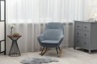 Pencerenin yanında şık mobilyalar ve oturma odasında perdeler. İç tasarım