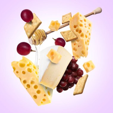 Menekşe arka planda peynir ürünleri. Farklı peynir, üzüm, kraker ve bal çeşitleri.