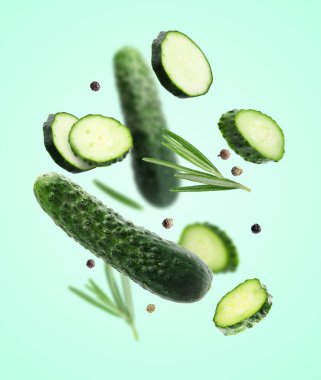 Taze salatalıklar, biberiye ve turkuaz arka plana dökülen biberler.