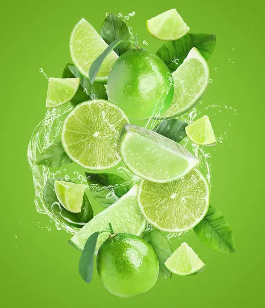 Yeşil arka planda taze limon ve su sıçratan bir içecek.