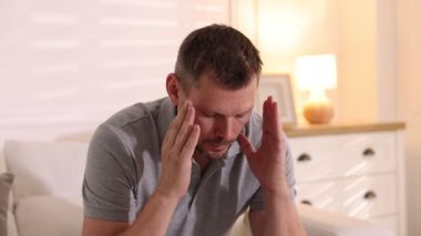 Panik atak. Evde sakinleşmek için nefes alan bir adam.