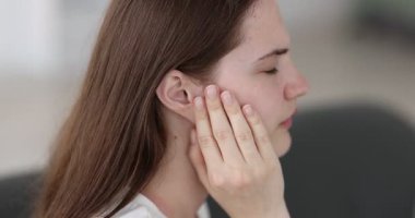 Evde kulak ağrısı çeken genç bir kadın, yakın plan.