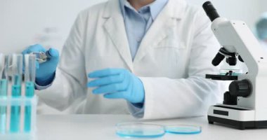 Tıbbi analiz. Laboratuvarda test tüpünden örnek alan bilim adamı, yakın plan.