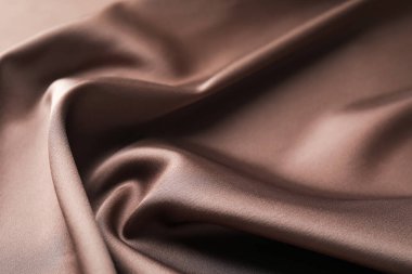 Arkaplan olarak buruşuk açık kahverengi ipek kumaş, yakın plan