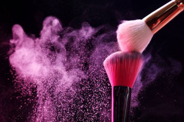 Siyah arka planda pembe göz farlı makyaj fırçaları, yakın plan. Metin için boşluk