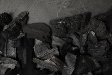 Siyah kömür parçaları gri masada, düz yatıyordu.