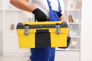 Kapalı mekanda alet çantası olan profesyonel bir tamirci.