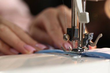 Bulanık koyu arkaplan, makro görünüm üzerinde dikiş makinesiyle çalışan kadın