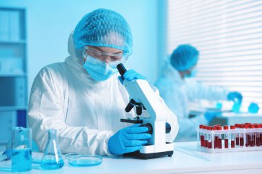 Tıbbi analiz. Laboratuvarda mikroskopla çalışan bilim adamı, seçici odaklanma