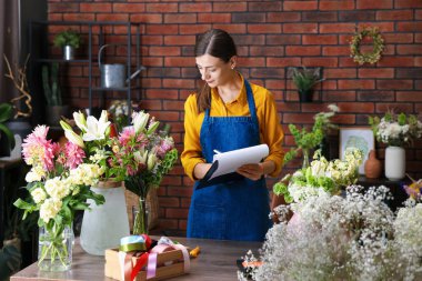 Dükkandaki ahşap masada çalışan profesyonel bir çiçekçi.