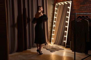 İçeride aynanın yanında saçını tarayan kadın.