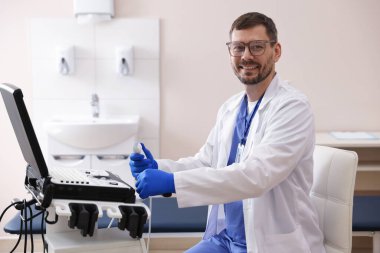 Klinikte ultrason makinesi olan profesyonel sonograf.