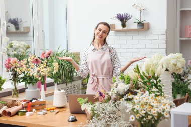 Dükkandaki ahşap masada çalışan profesyonel bir çiçekçi.