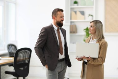 Ofiste dizüstü bilgisayarla çalışan iş ortakları
