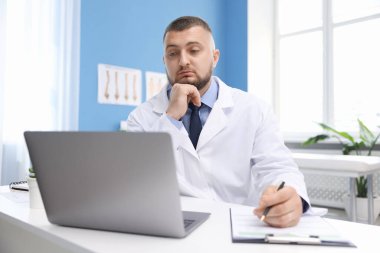 Klinikte bilgisayarla online danışmanlık yapan bir doktor