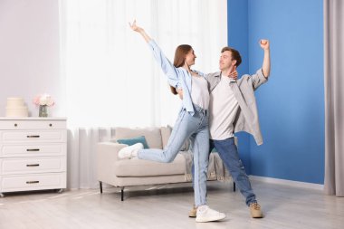 Mutlu genç çift evde dans ediyor.