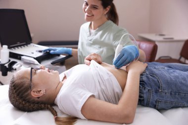 Sonograf, klinikte kızın karın ultrasonu muayenesini yönetiyor.