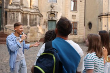 Gezinti sırasında mikrofon ve turist grubuyla şehir caddesinde rehberlik