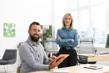 Ofiste tabletle gülümseyen iş ortaklarının portresi