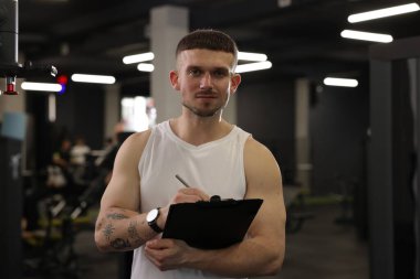 Spor merkezinde panosu olan kişisel antrenör.