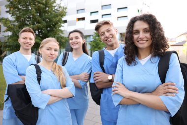 Sırt çantalı bir grup tıp öğrencisi dışarıda.