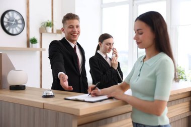 Otel resepsiyonunda resepsiyonist ve müşteri