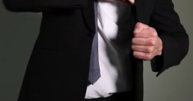 Gri arka planda cüzdandaki dolarları sayan adam, yakın plan.