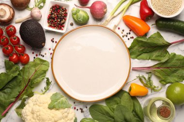 Sağlıklı vejetaryen yemekleri. Beyaz mermer masa üzerinde farklı ürünlerle çevrili boş tabak.