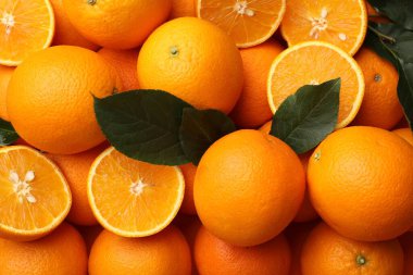 Arka plan olarak sulu portakallar ve yeşil yapraklar, üst görünüm