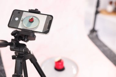 Stüdyoda akıllı telefonla lezzetli bir tatlı çekmek, seçici bir odak noktası. Profesyonel yemek fotoğrafçılığı.