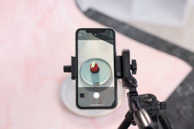 Stüdyoda güzel bir tatlı ve akıllı telefon. Profesyonel yemek fotoğrafçılığı.