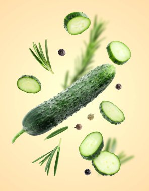 Taze salatalıklar, biberiye ve biberler koyu bej arka plana dökülüyor.