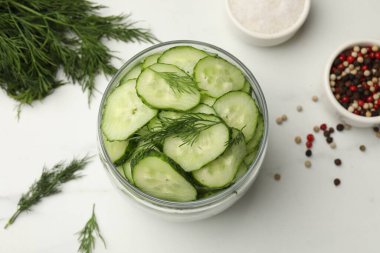 Turşu yapıyorum. Taze salatalıklar ve diğer malzemeler beyaz mermer masada, düz yerde.