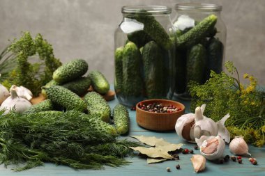 Turşu yapıyorum. Taze salatalıklar ve diğer malzemeler açık mavi ahşap masada, yakın plan.