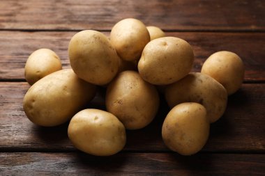 Tahta masaya çiğ patates yığını, yakın plan.