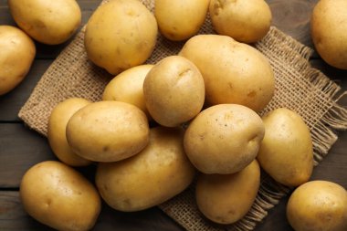 Tahta masada bir sürü çiğ patates ve çuval bezi vardı.