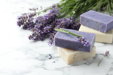 Sabun barları ve lavanta çiçekleri beyaz mermer masada, yakın plan. Metin için boşluk