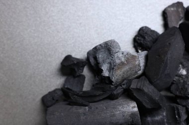 Gri masa üzerinde siyah kömür parçaları, üst manzara. Metin için boşluk