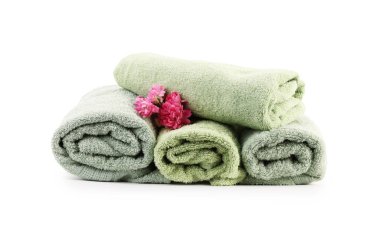 Yuvarlanmış havlular ve çiçekler beyazda izole edilmiş.