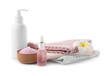 Beyaz üzerine izole edilmiş waffle havluları ve kozmetik ürünleri olan spa kompozisyonu