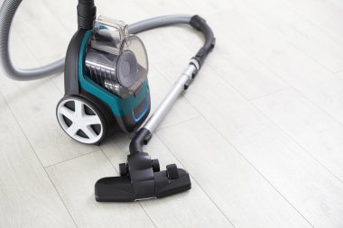 Tahta zeminde bir elektrikli süpürge. Ev aletleri