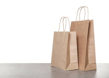 Gri masada beyaz arkaplana karşı iki kese kağıdı.