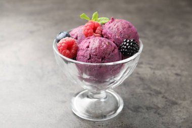 Taze böğürtlenli lezzetli şerbet ve tatlı kasesinde nane şekeri. Gri desenli masa, yakın plan.