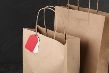 Koyu arkaplanda boş etiketli kese kâğıdı torbaları, yakın plan.