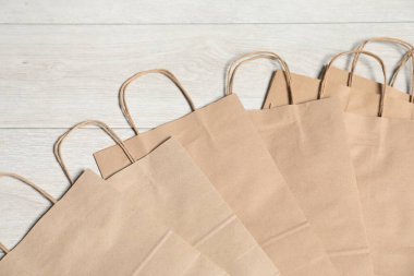 Açık gri ahşap masadaki kese kâğıtları düz yatıyordu.