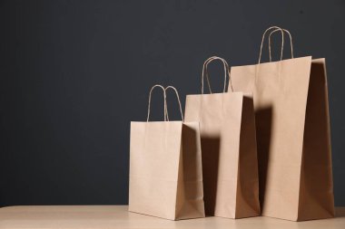 Kravat kâğıdı torbaları ahşap masanın üzerinde, karanlık arka plana karşı, yakın plan. Metin için boşluk